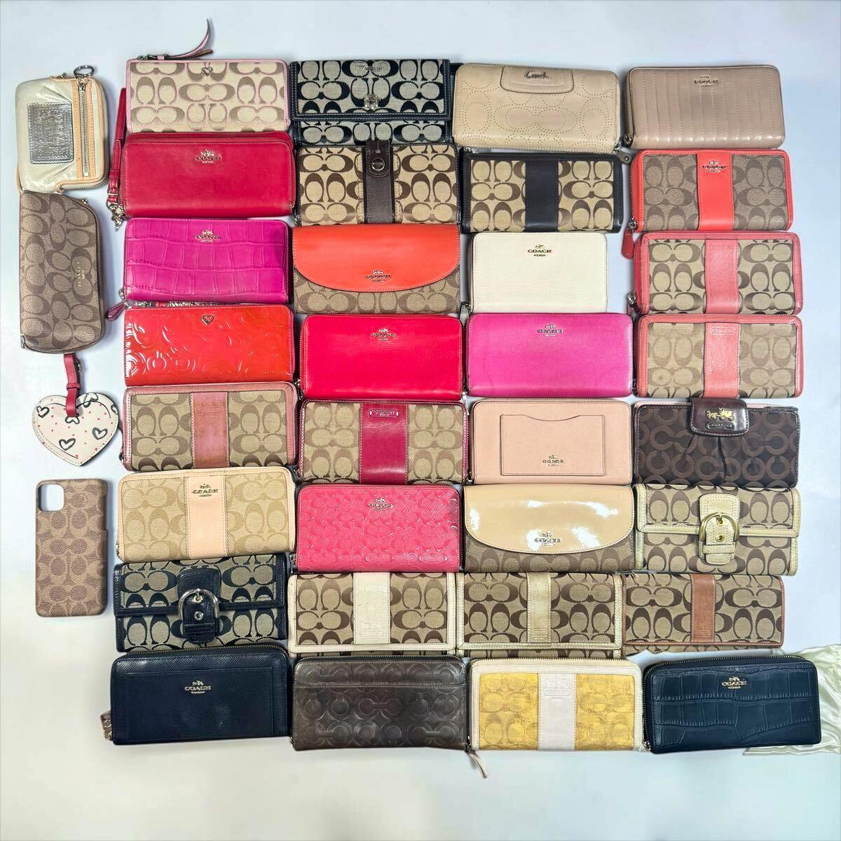 Many Coach wallets and small accessories arranged in a grid on a white background.