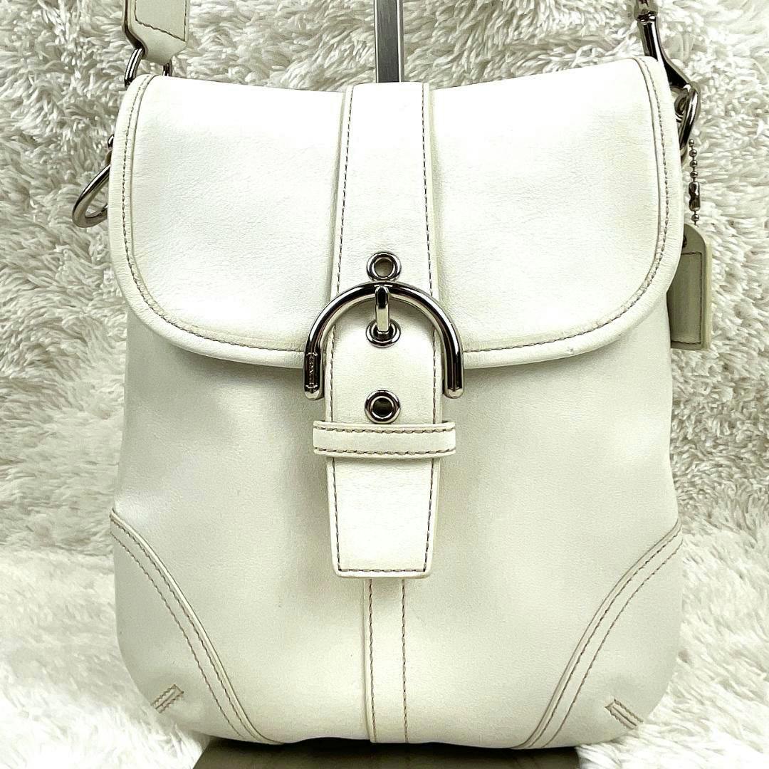 Front view of the white COACH Soho cow leather shoulder bag showing the flap and metal buckle closure.