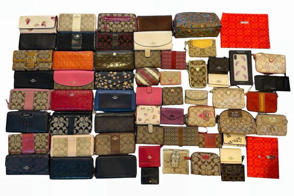 Multiple Coach wallets and pouches in various signature prints and colors arranged on a white background, shown as a bulk set.