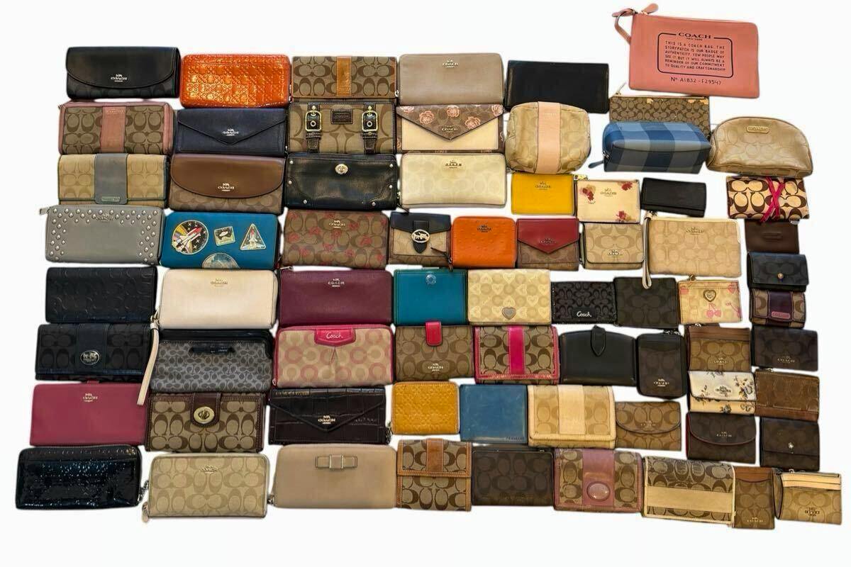 A large assortment of Coach wallets and small leather goods laid out in rows on a white background, showing various styles and colors.