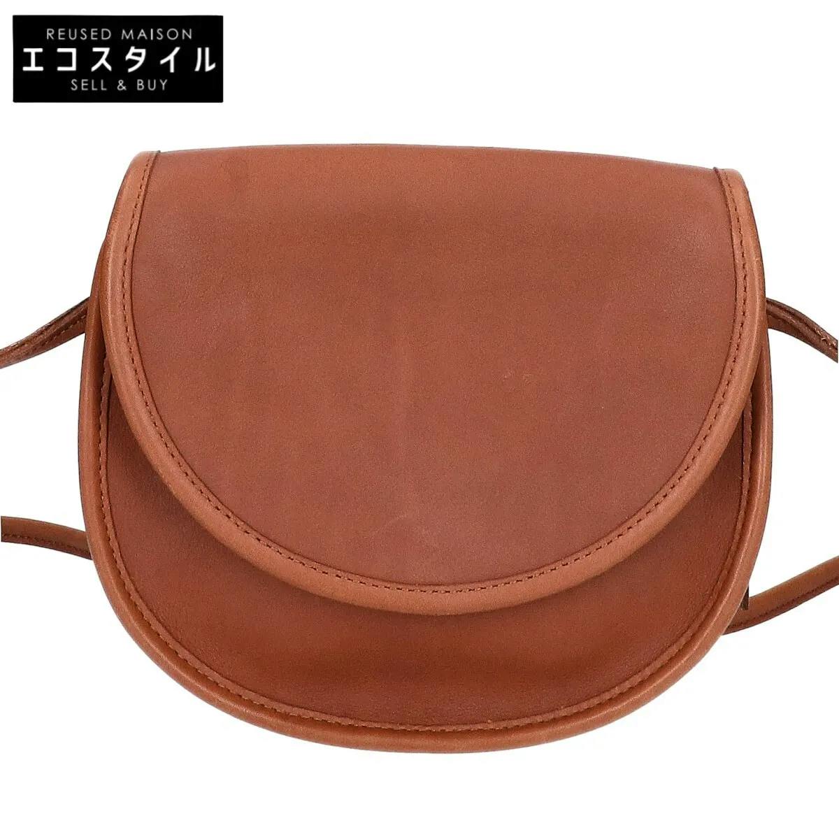 Front view of a brown leather Coach flap bag.