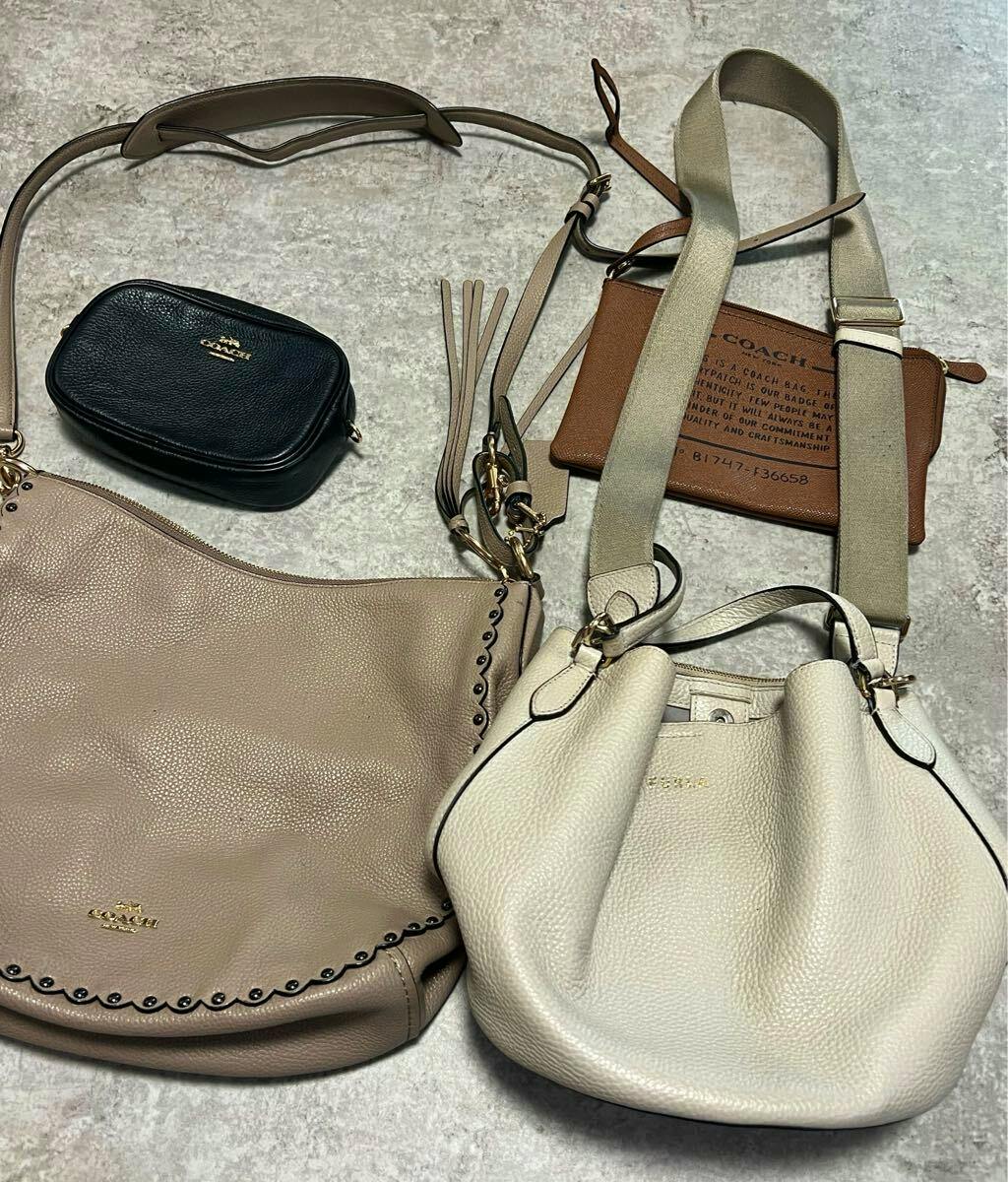 Four leather bags and pouches, including Coach pieces, arranged on a gray textured surface.