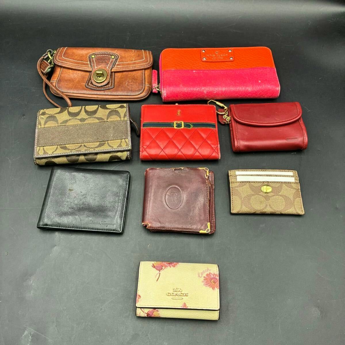 Nine wallets and small leather goods, including Coach items, arranged on a dark background.