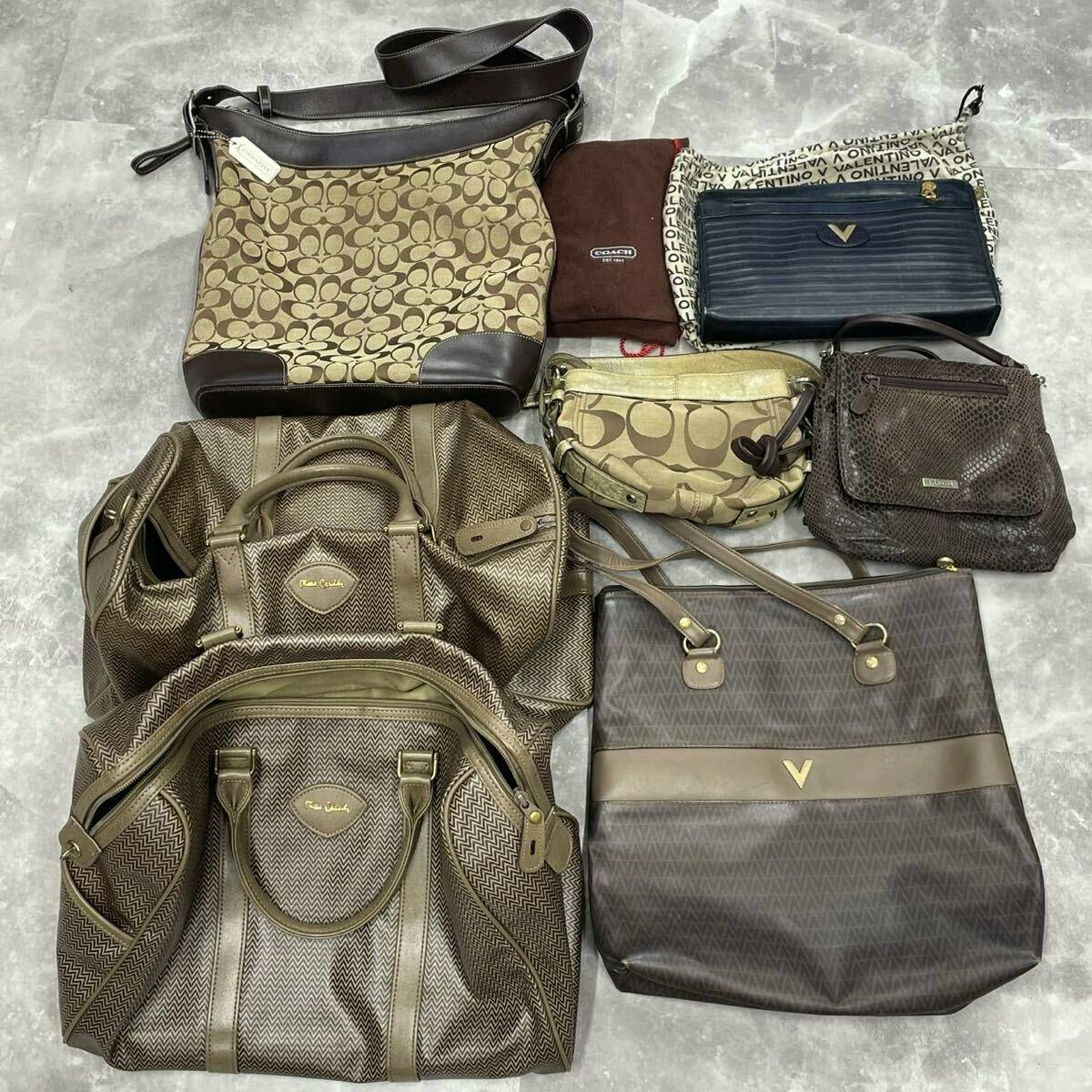 Seven bags and purses of various styles and brown tones arranged on a gray floor, shown together as a set.
