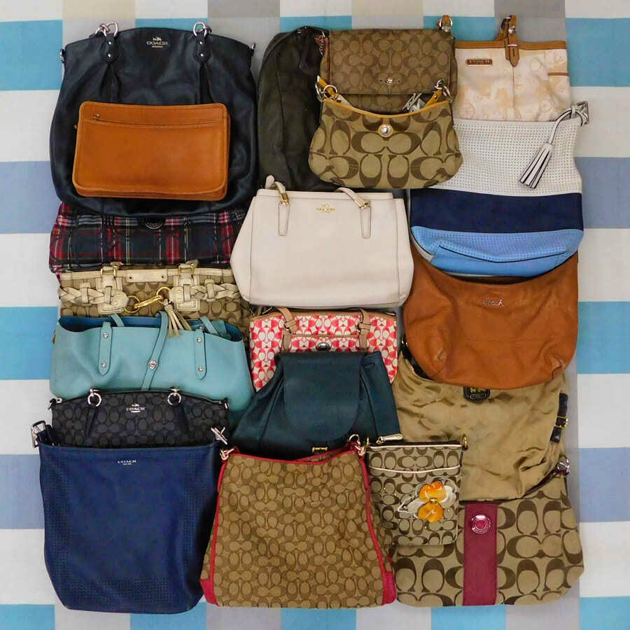 Multiple COACH bags in various styles and colors arranged on a checkered background.