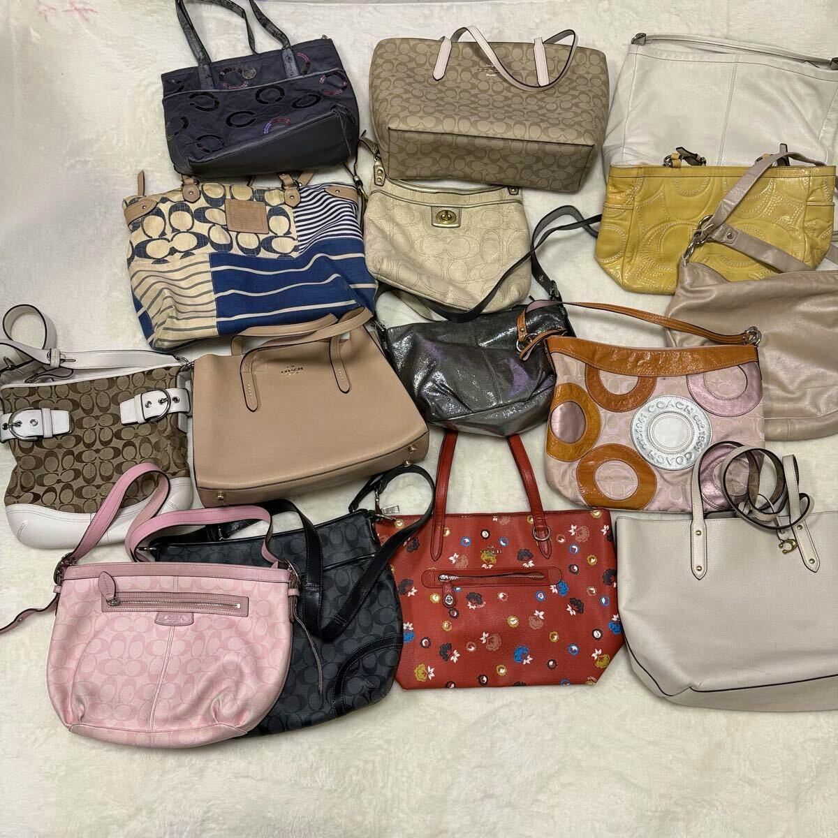 A selection of COACH handbags and shoulder bags arranged on a light surface, showing multiple styles and colors from the lot.