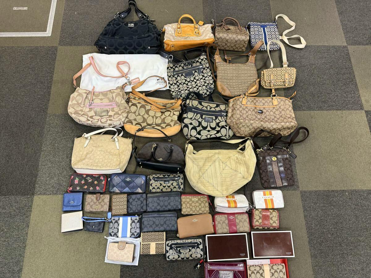 Multiple COACH handbags, wallets, and small accessories arranged on a carpeted floor, shown together as a bundled set.