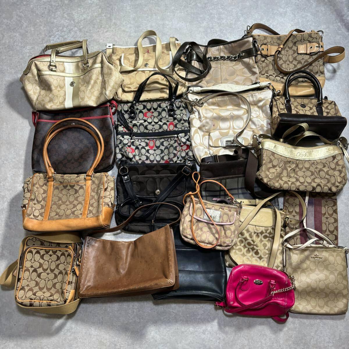 Multiple Coach tote, shoulder, and handbag styles arranged together on a gray surface in a flat lay.