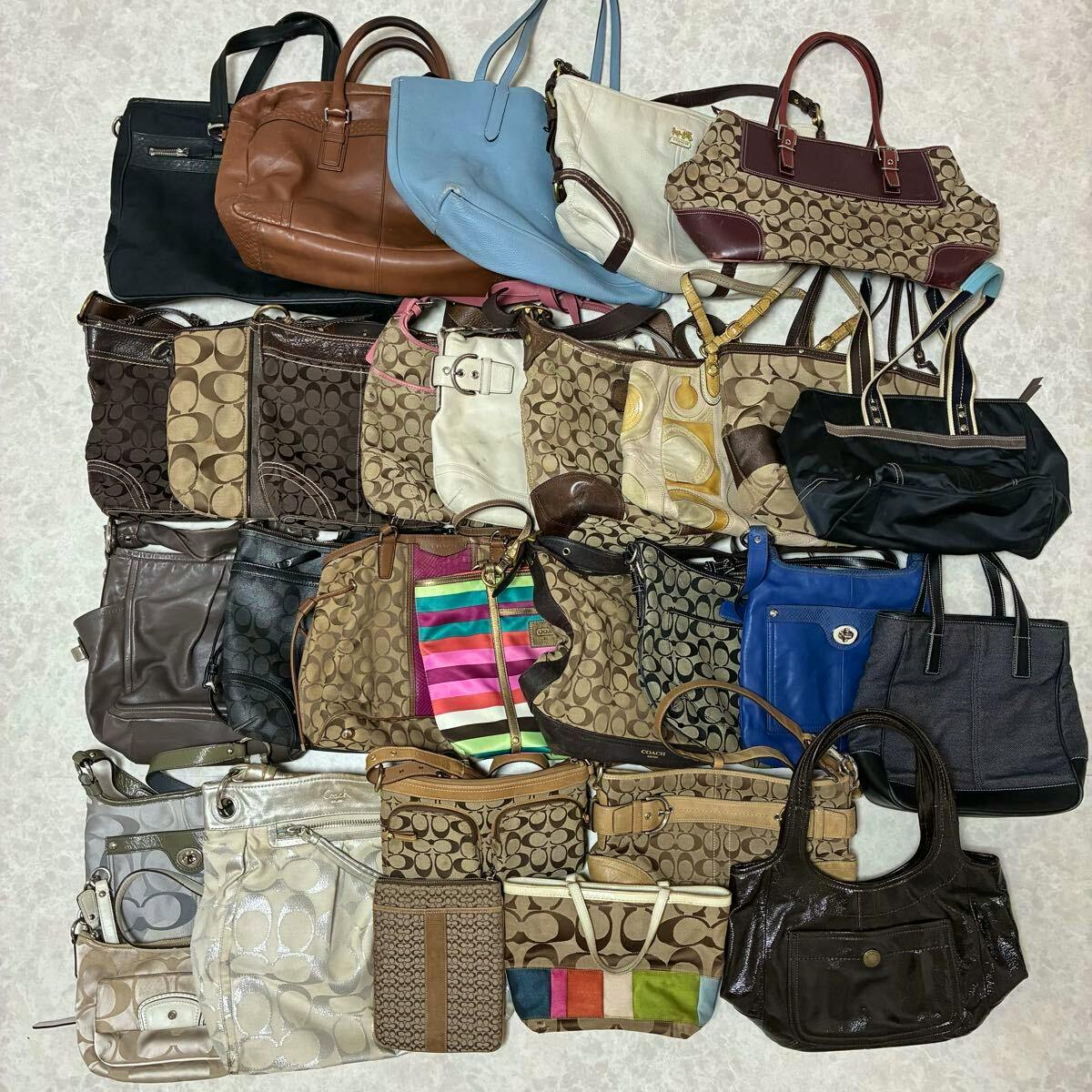Top-down photo of 30 Coach bags and purses arranged on a floor, showing various signature monogram and leather styles.