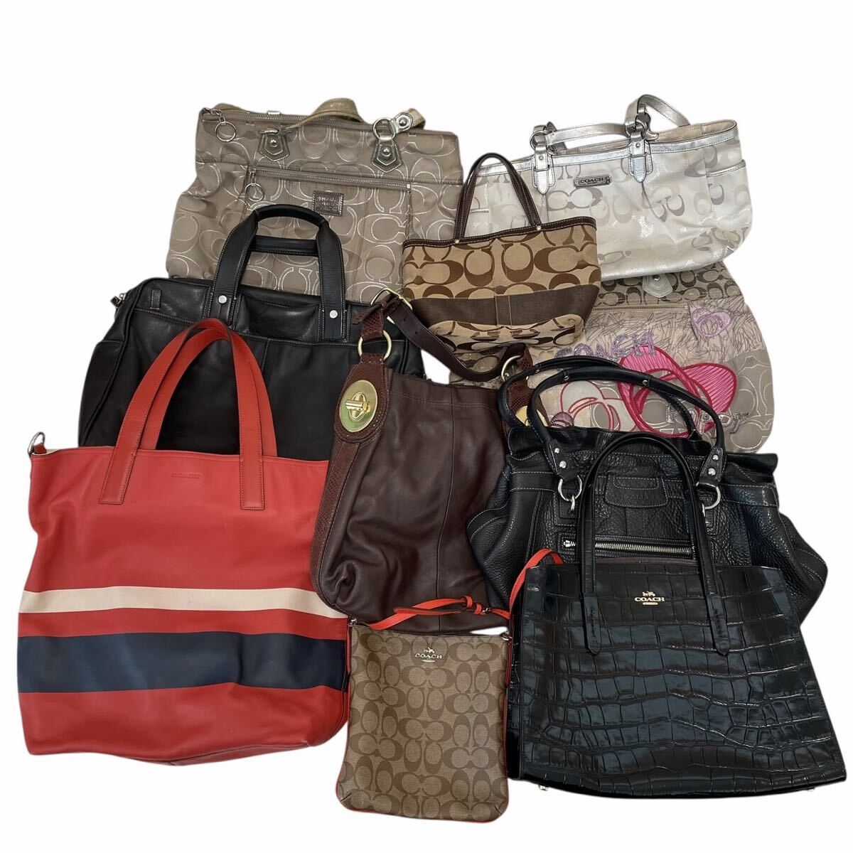 Photo of a set of Coach handbags and totes arranged on a white background.