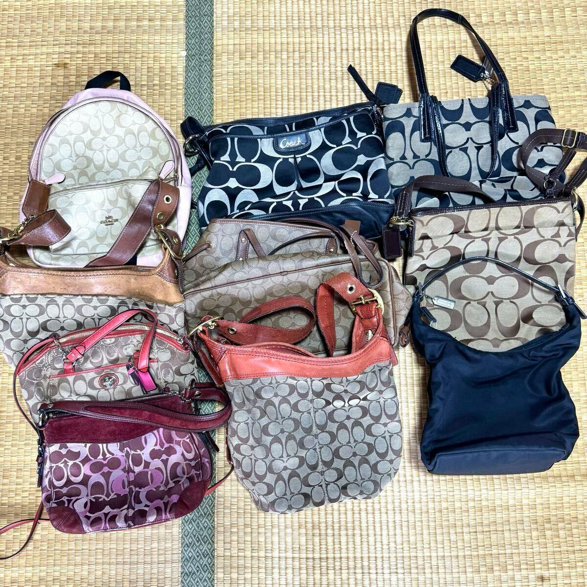 A set of Coach bags arranged on a tatami mat showing various signature canvas and leather styles.