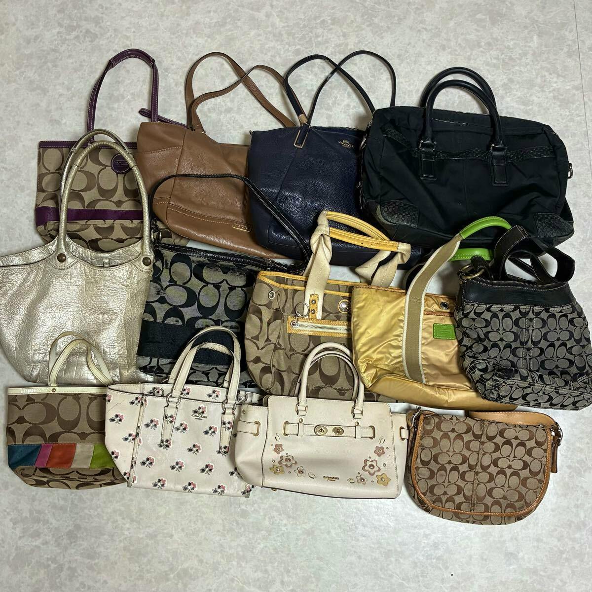 Thirteen COACH bags and totes in various colors and patterns arranged on a floor.