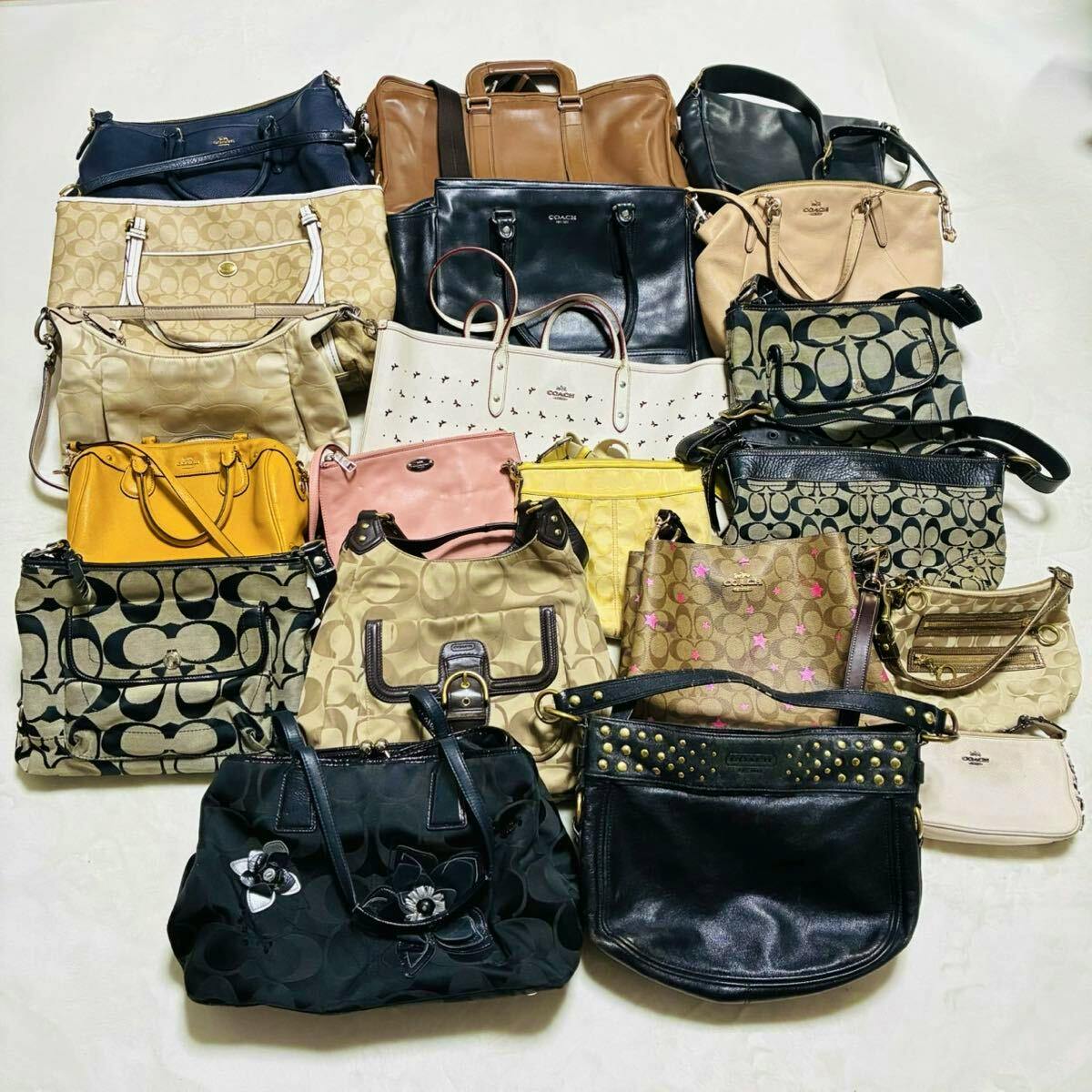 A collection of multiple COACH handbags and shoulder bags arranged on a flat surface.