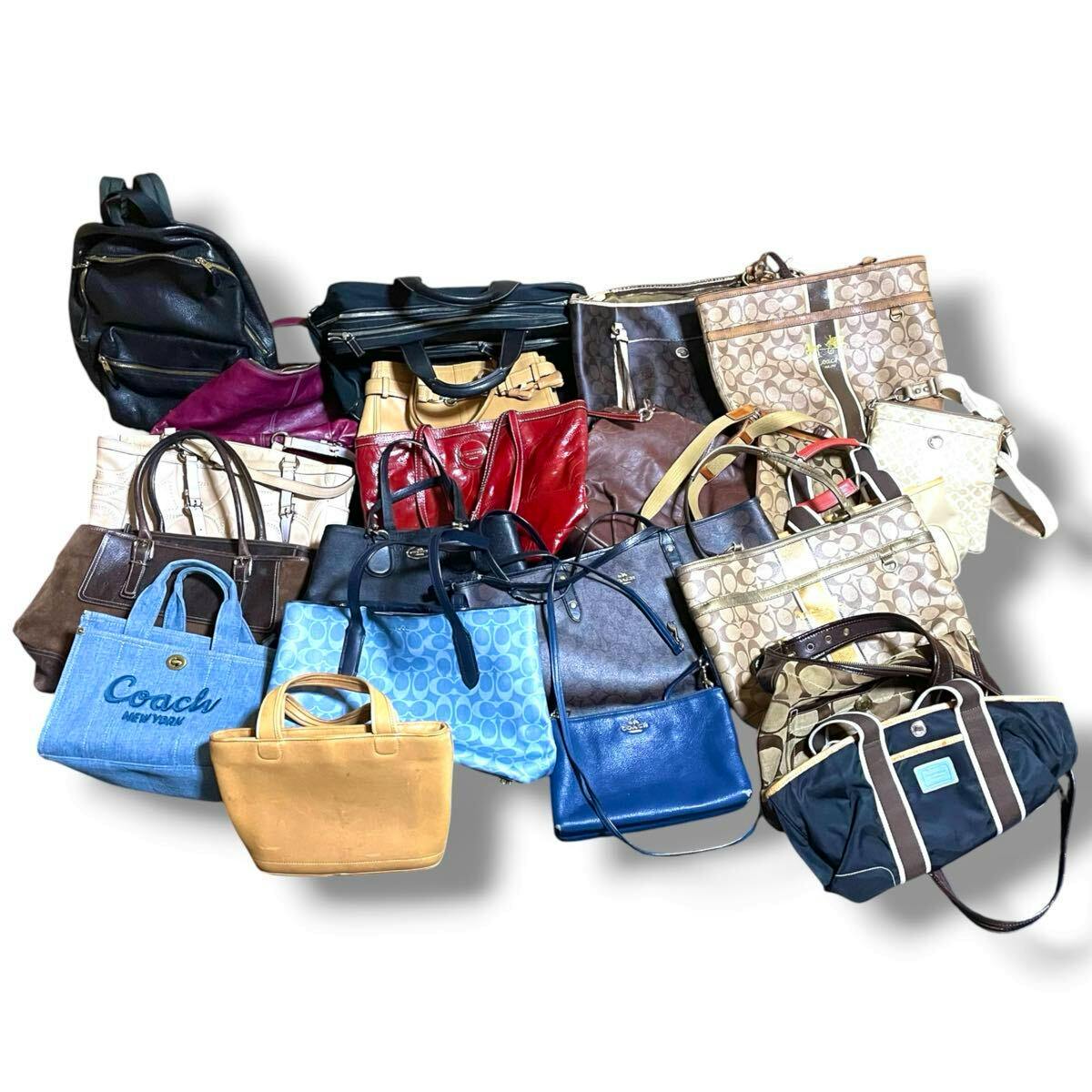 Group of various Coach bags (totes, shoulder bags, backpacks) arranged together on a white background.