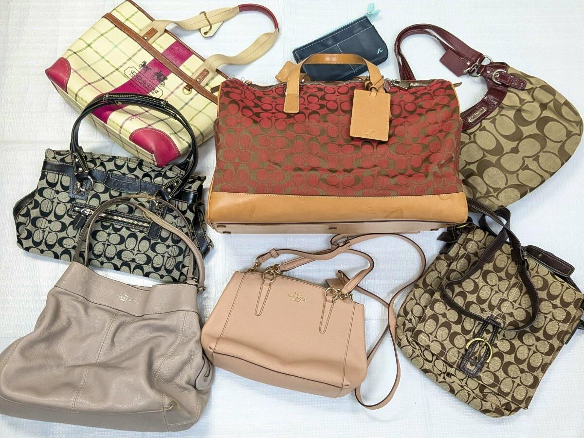 Top-down photo of multiple Coach bags and a Kitamura pouch arranged on a light surface.