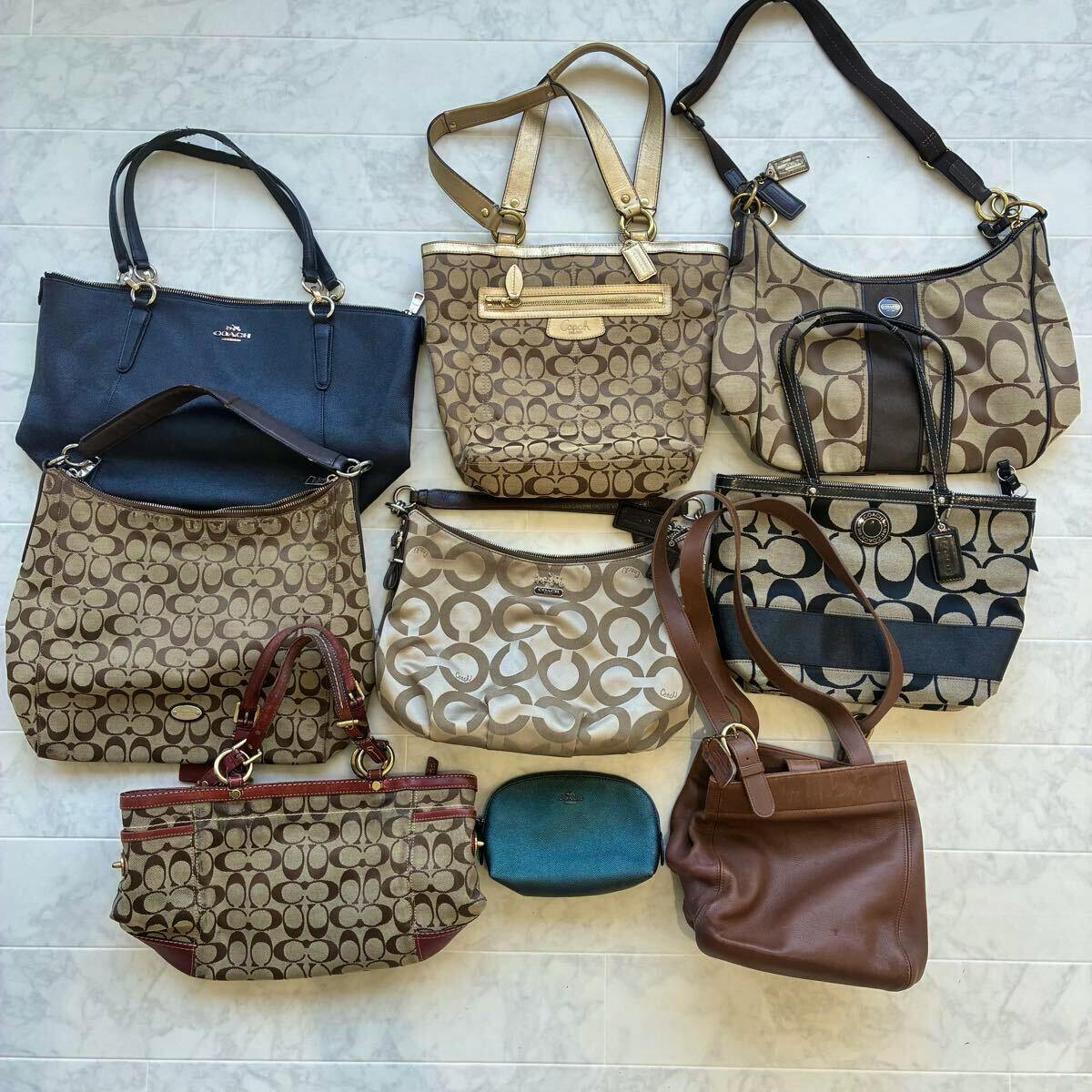 Nine COACH bags and a small COACH pouch laid flat on a light tiled floor, showing signature C canvas patterns and leather styles.