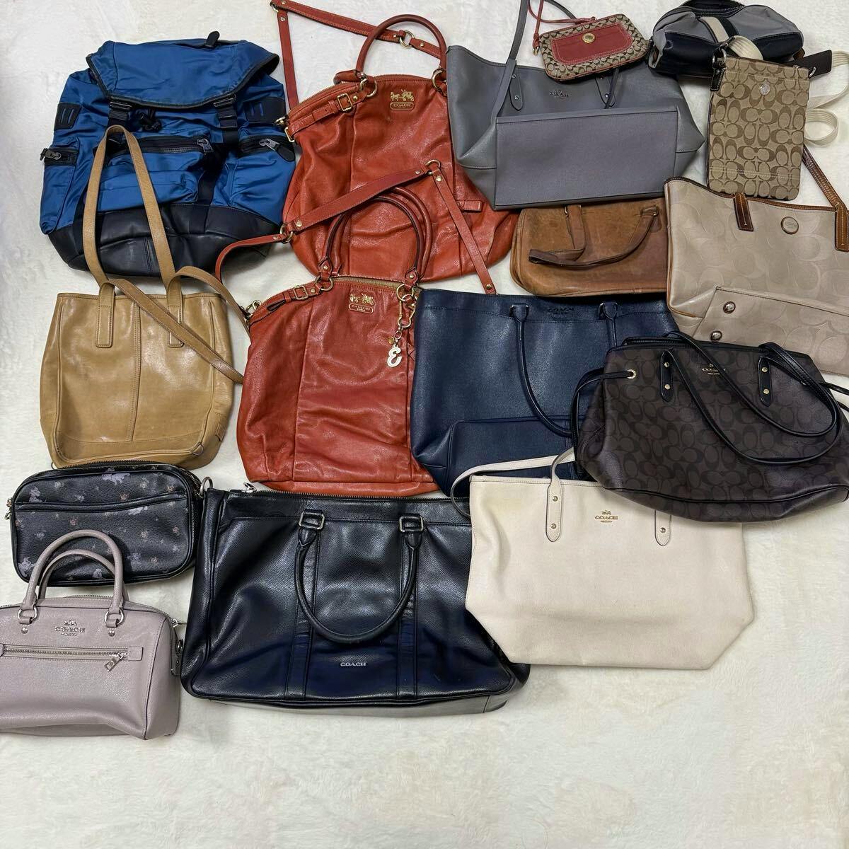 Top-down photo showing a collection of Coach handbags, totes, pouches, and backpacks arranged on a light surface.