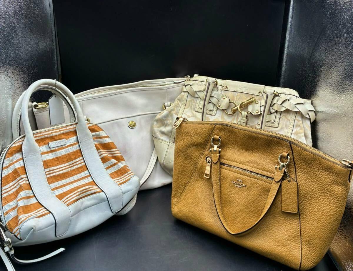 Four Coach bags arranged together, showing different styles and colors.