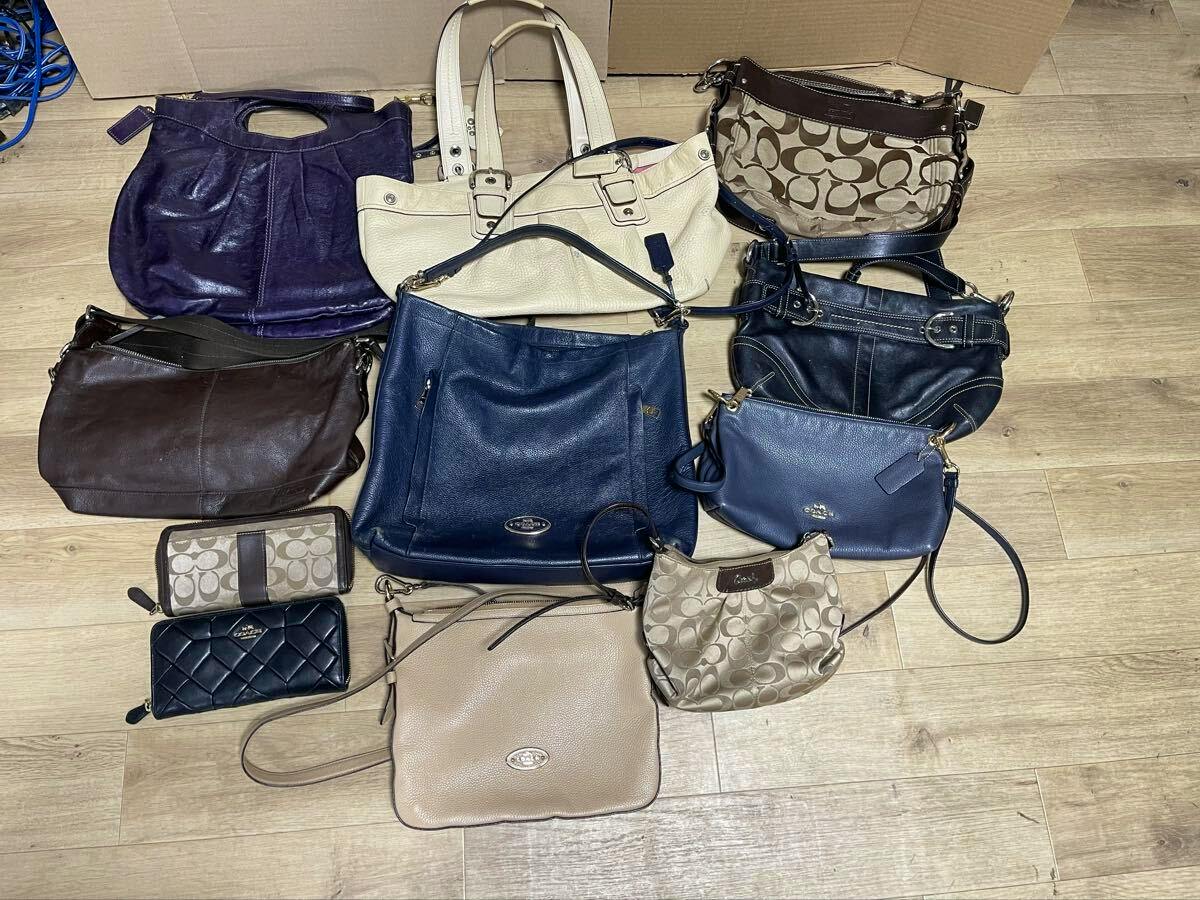 Multiple Coach bags and wallets arranged on a wooden floor, showing various colors and styles.
