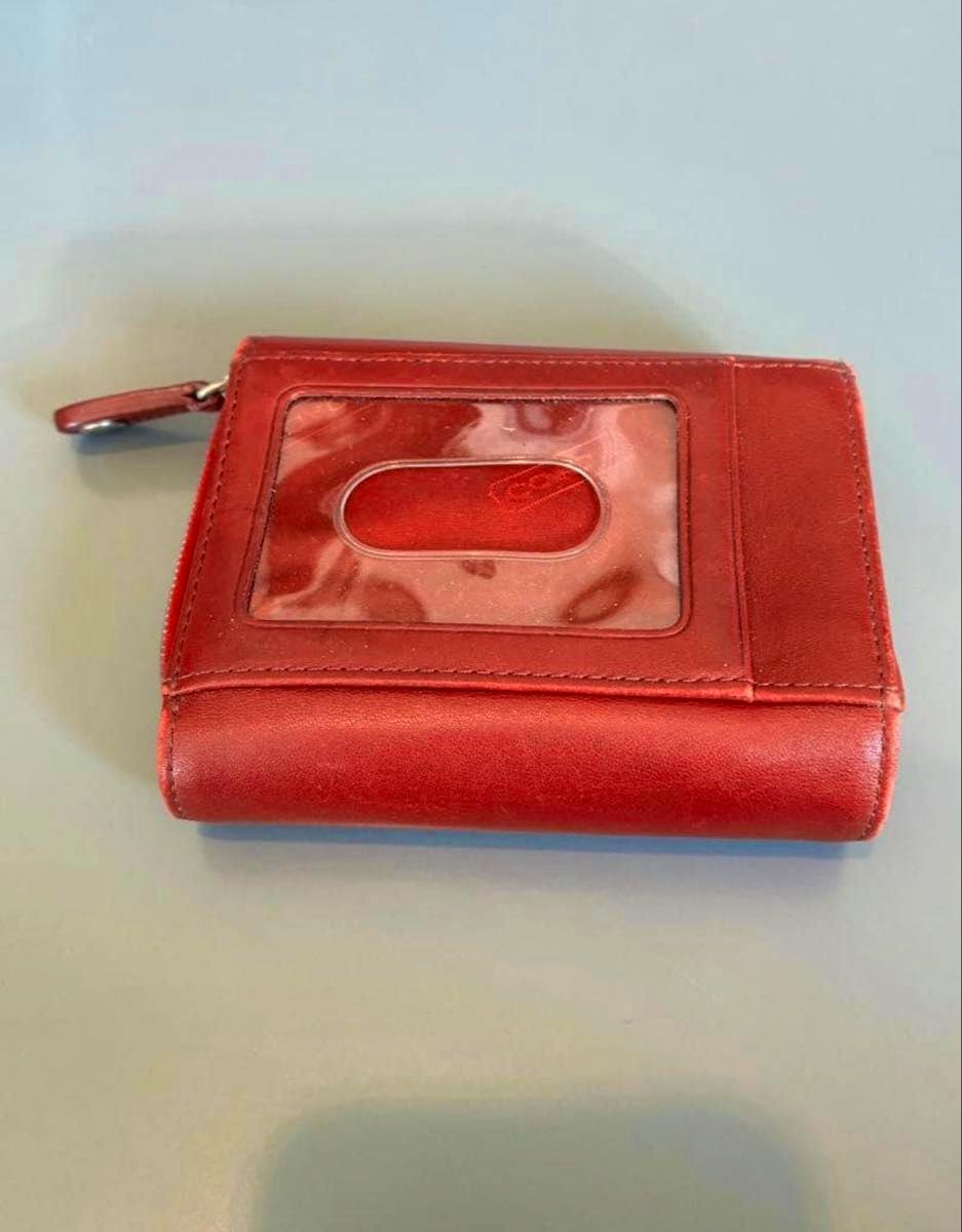 Red COACH leather bifold wallet with a clear ID window shown closed on a light surface.