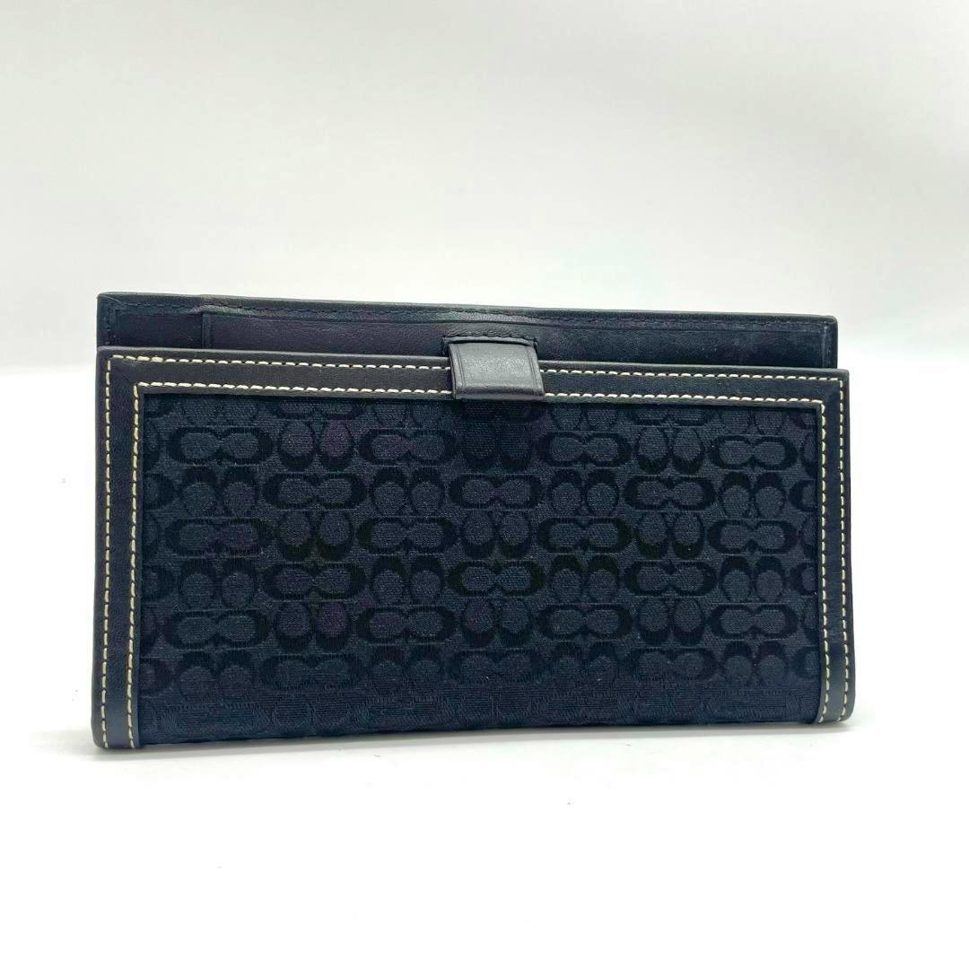 Black Coach slim long wallet in signature black canvas with contrast white stitching, shown closed on a white background.