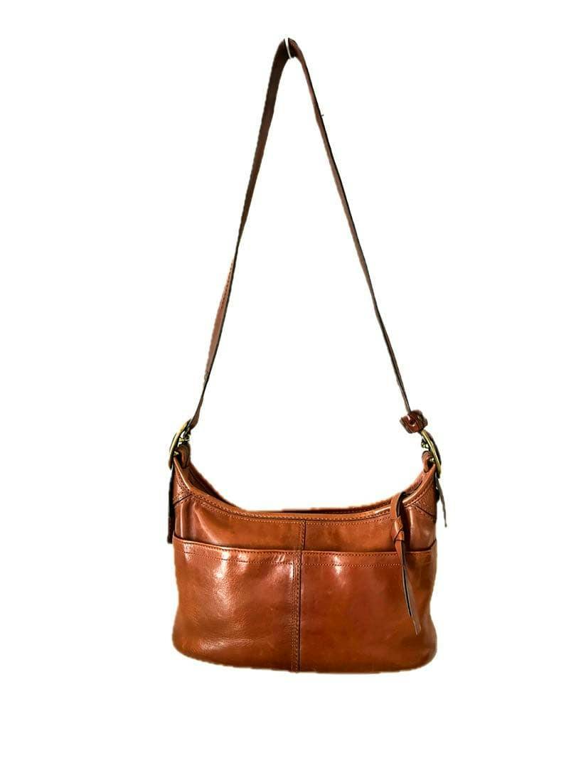 Brown cow leather COACH shoulder bag with a single shoulder strap shown front-facing.