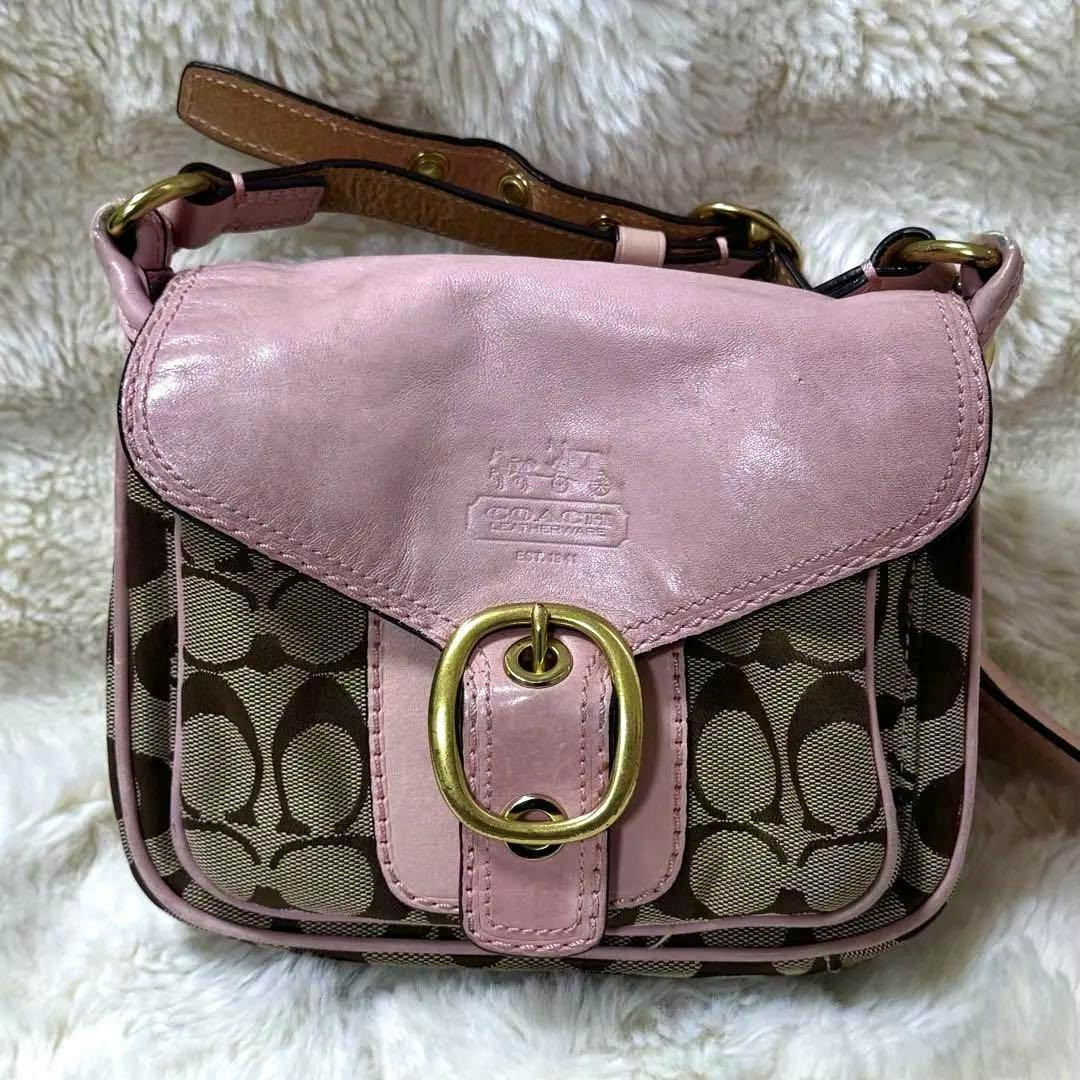 Front view of the COACH Bleecker Soho shoulder bag in pink with signature monogram canvas, pink leather flap, and gold-tone buckle.