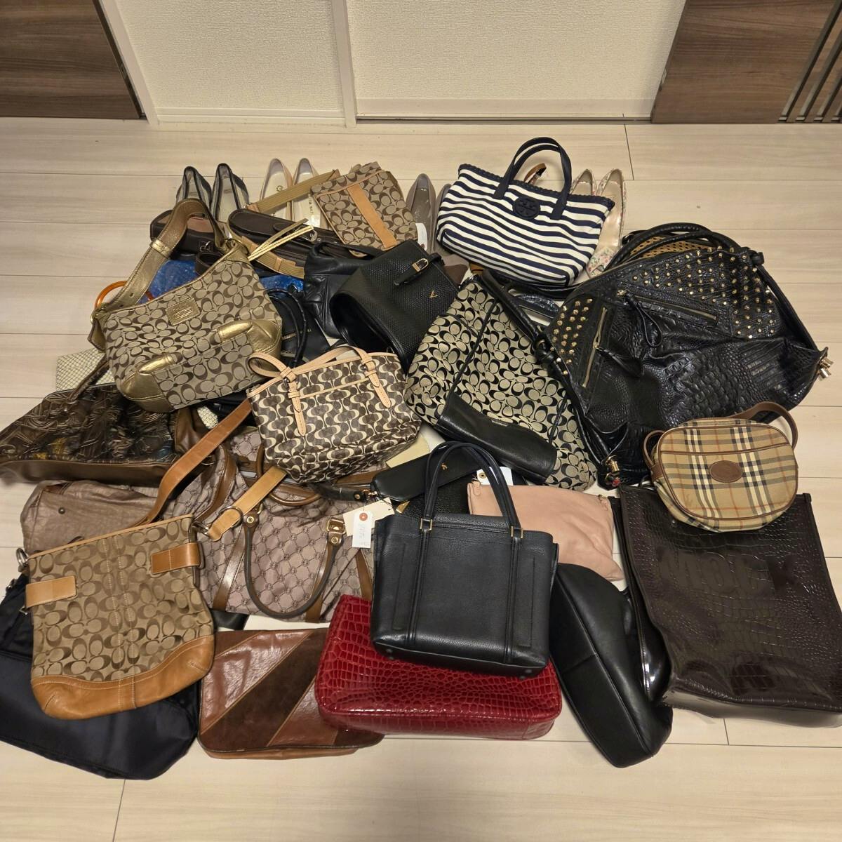 Overhead photo showing a large assortment of handbags and some shoes spread on the floor as a bulk set.