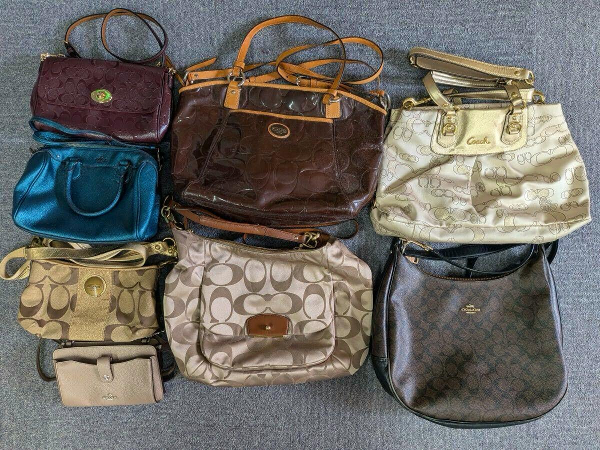 Eight Coach shoulder bags in assorted colors and styles laid out on a gray surface, shown as a bulk set.