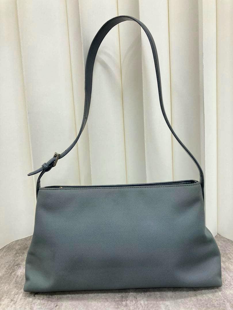 Front view of the Coach one-shoulder canvas bag showing the body and single shoulder strap against a neutral background.