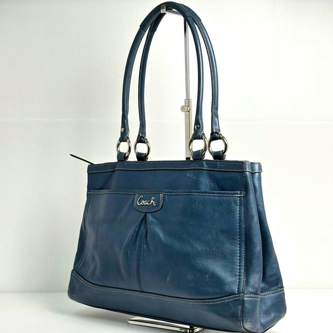 Blue navy Coach tote bag with double shoulder handles and a front Coach logo, photographed against a white background.