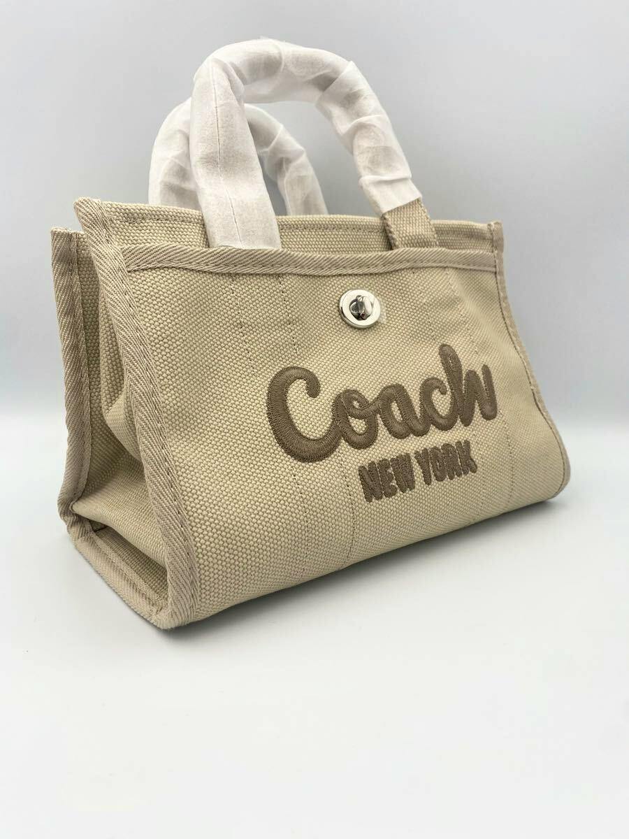 Beige COACH bag (cow leather) with embroidered "Coach New York" logo photographed on a white background.