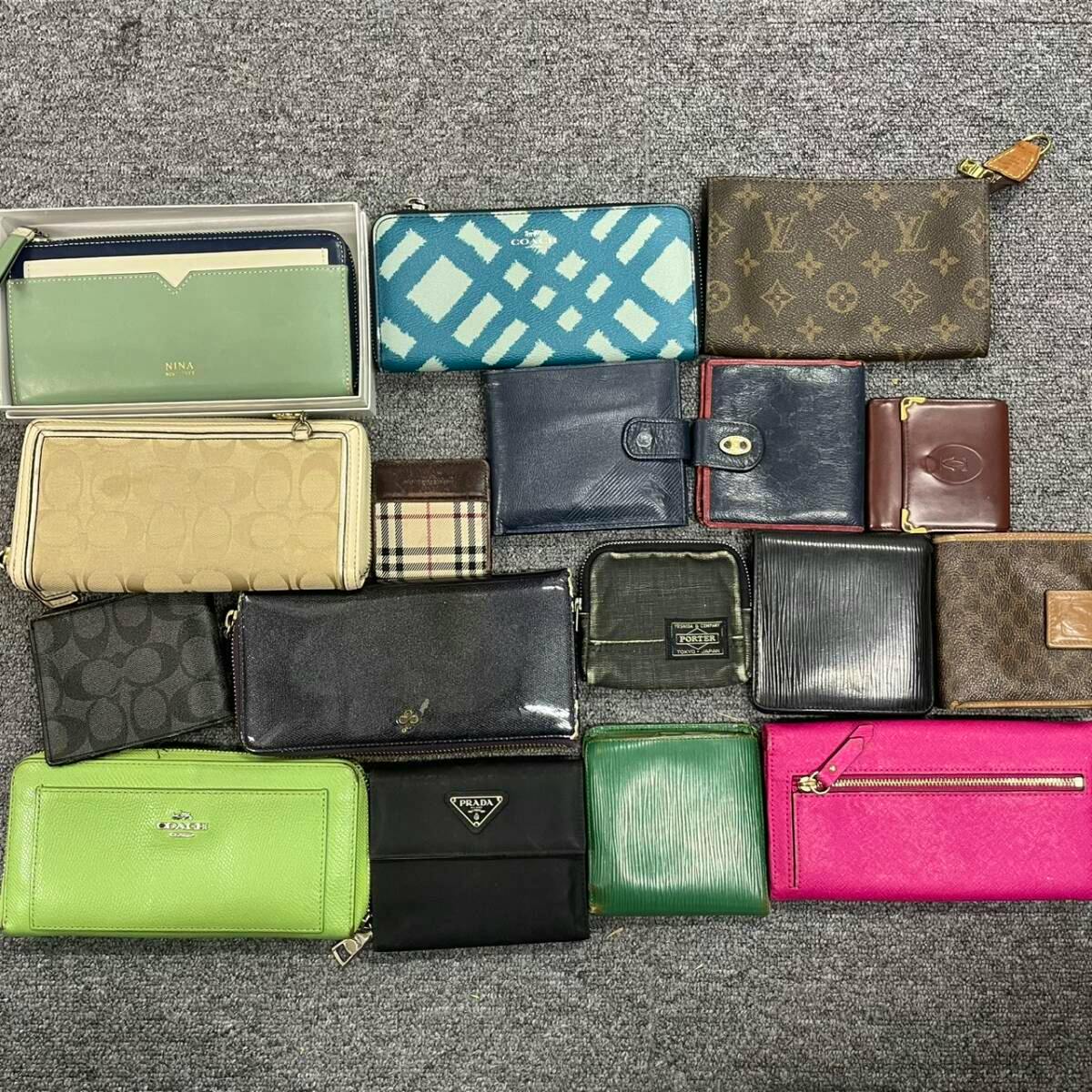 Multiple wallets and small pouches in various colors and patterns laid out on a gray carpet, showing a bulk set of wallets.
