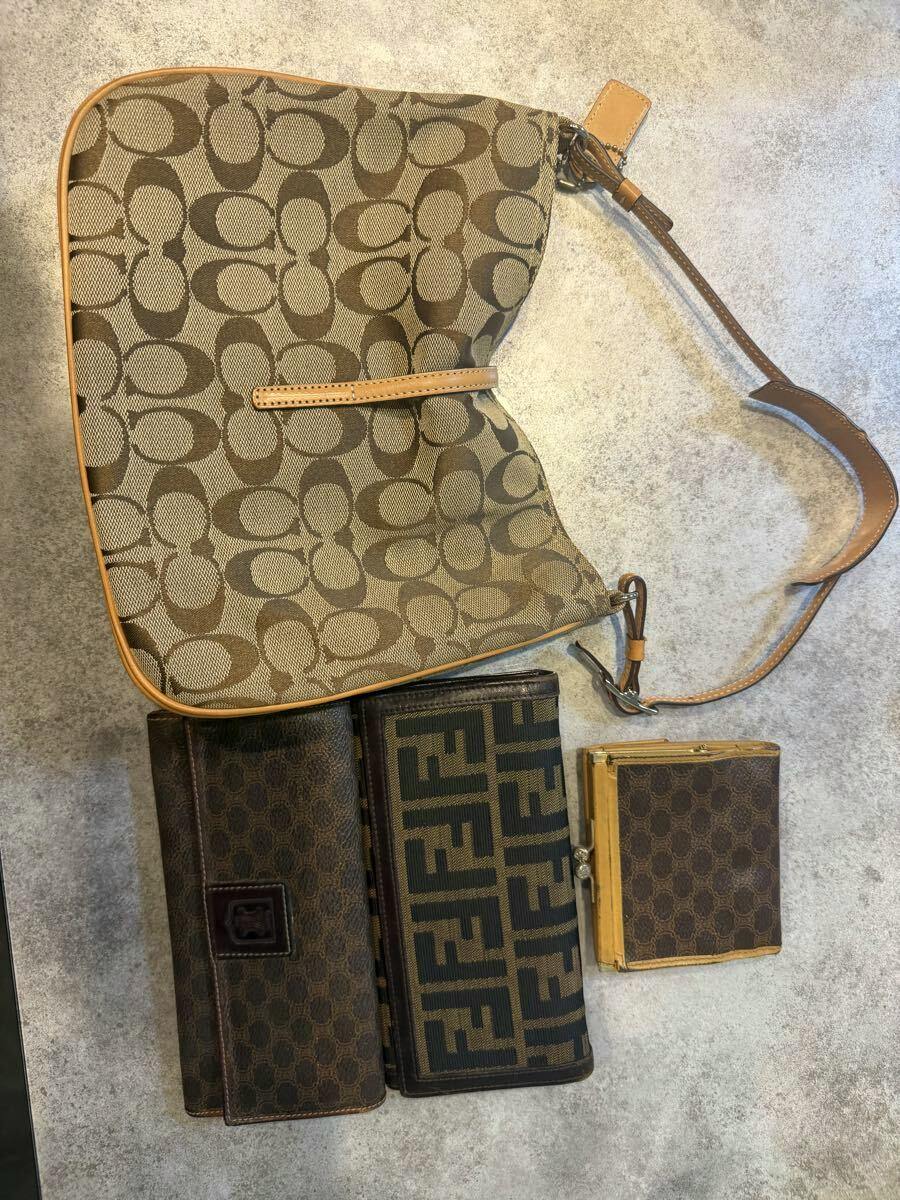 Top-down photo of the signature canvas shoulder bag with three wallets laid flat on a light surface.