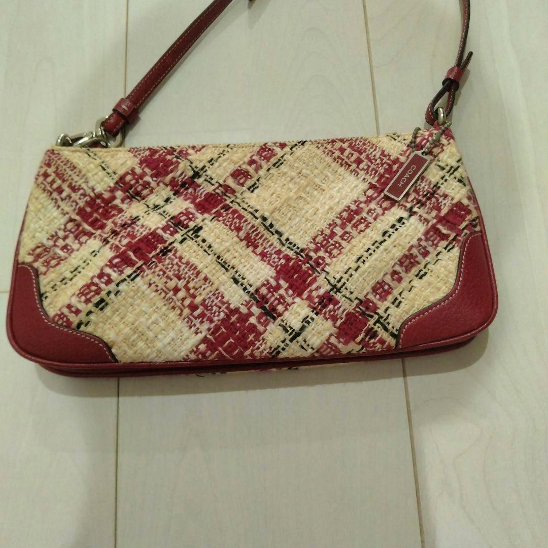 Front view of the COACH handbag in red and cream check tweed-style fabric with red leather trim and a strap.