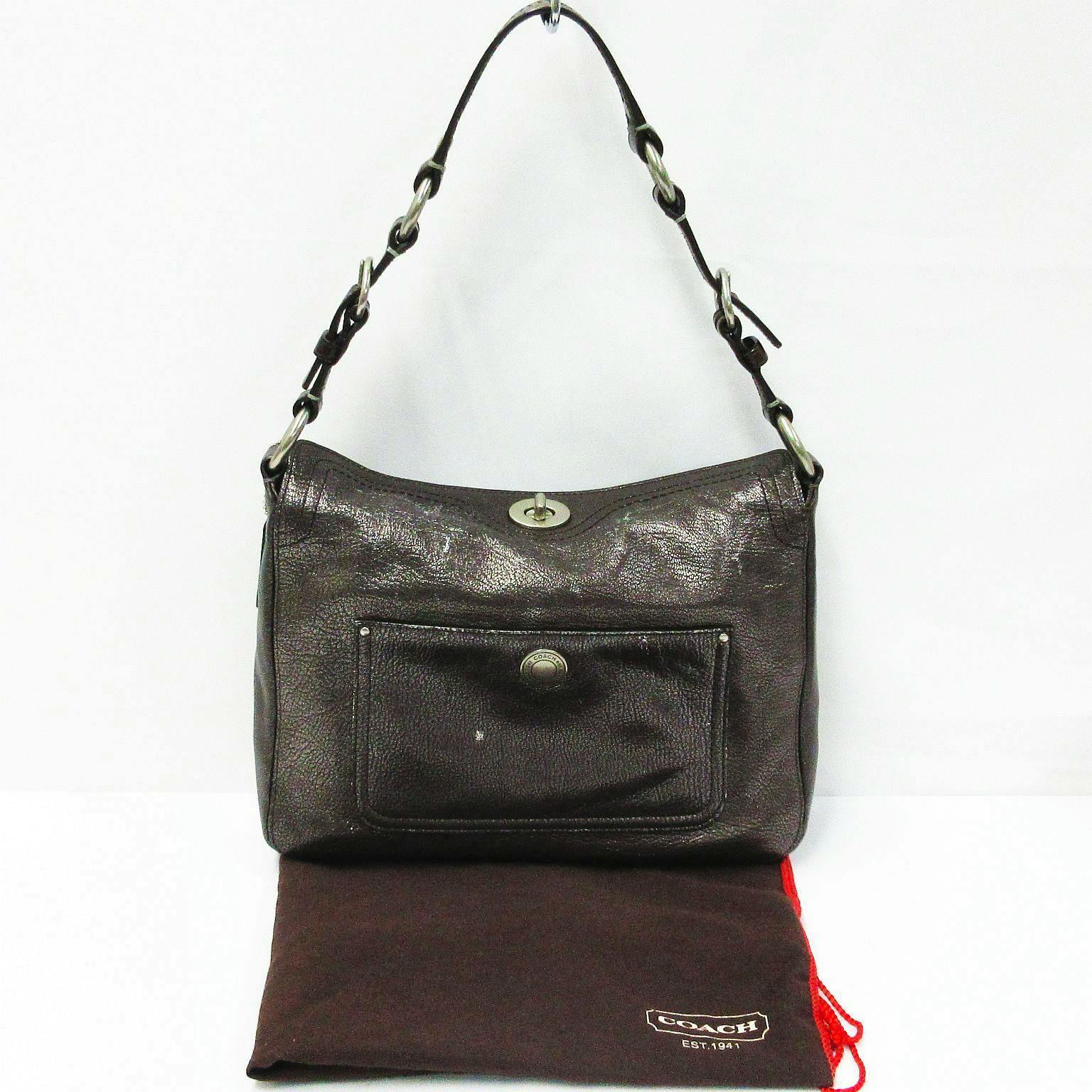 Front view of the gray metallic Coach one-shoulder leather bag with its strap and front pocket visible.