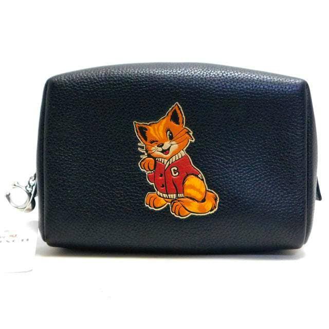 Front view of a black cow leather Coach cosmetic pouch with a cartoon cat patch on the front.