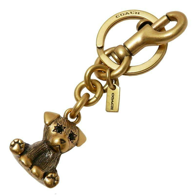 Gold-tone Coach puppy keyring and bag charm (zinc alloy) showing the puppy charm, chain links, COACH tag, round keyring, and clasp.