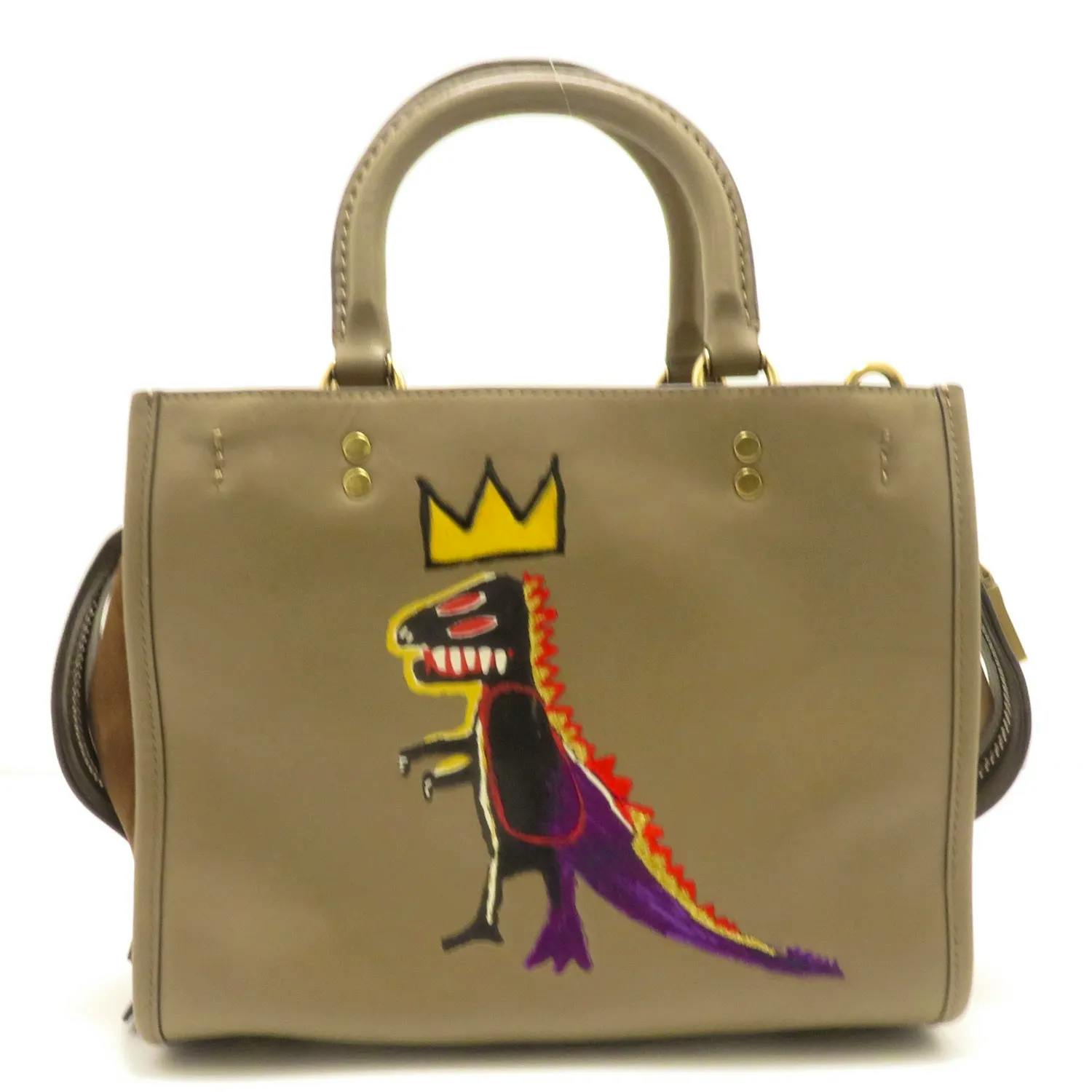 Brown leather COACH 3-way women's handbag front showing a painted dinosaur motif with a yellow crown.