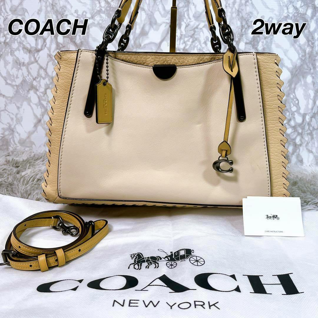 Front view of the Coach Dreamer 36 colorblock bag with whipstitch detailing, shown with a detachable strap and Coach dust bag.