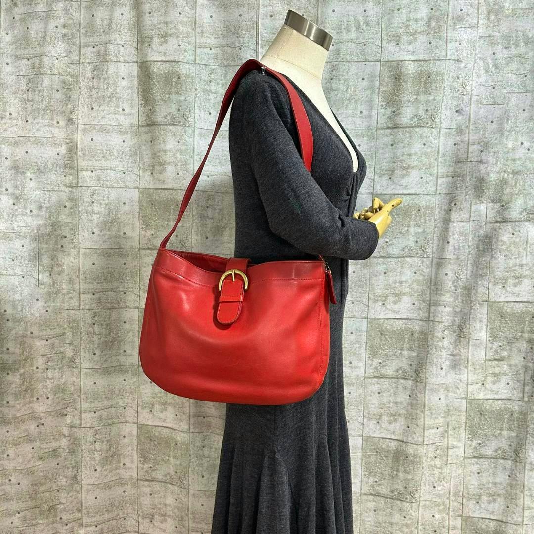 Red COACH Eldridge Hobo cow leather shoulder bag shown on a mannequin from the side.