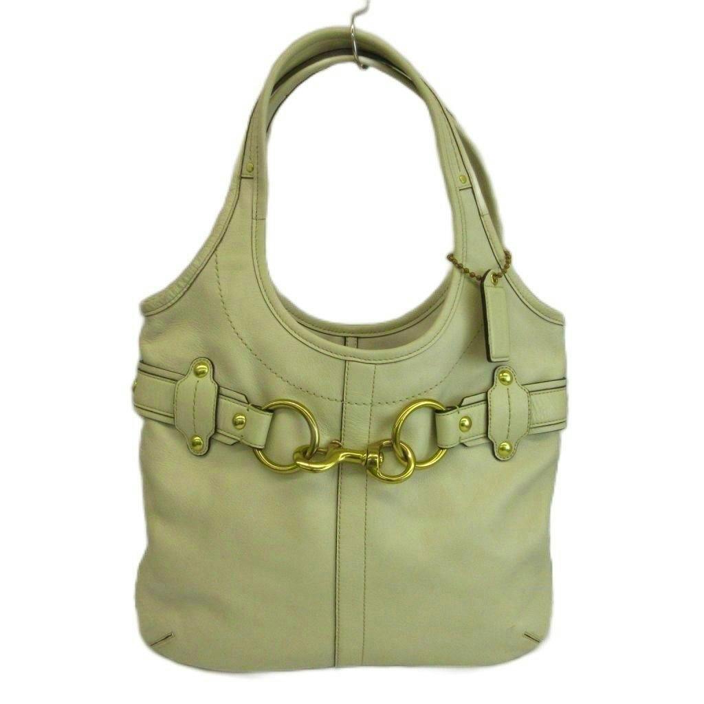 Front view of a white Coach leather belted hobo tote bag with gold hardware.