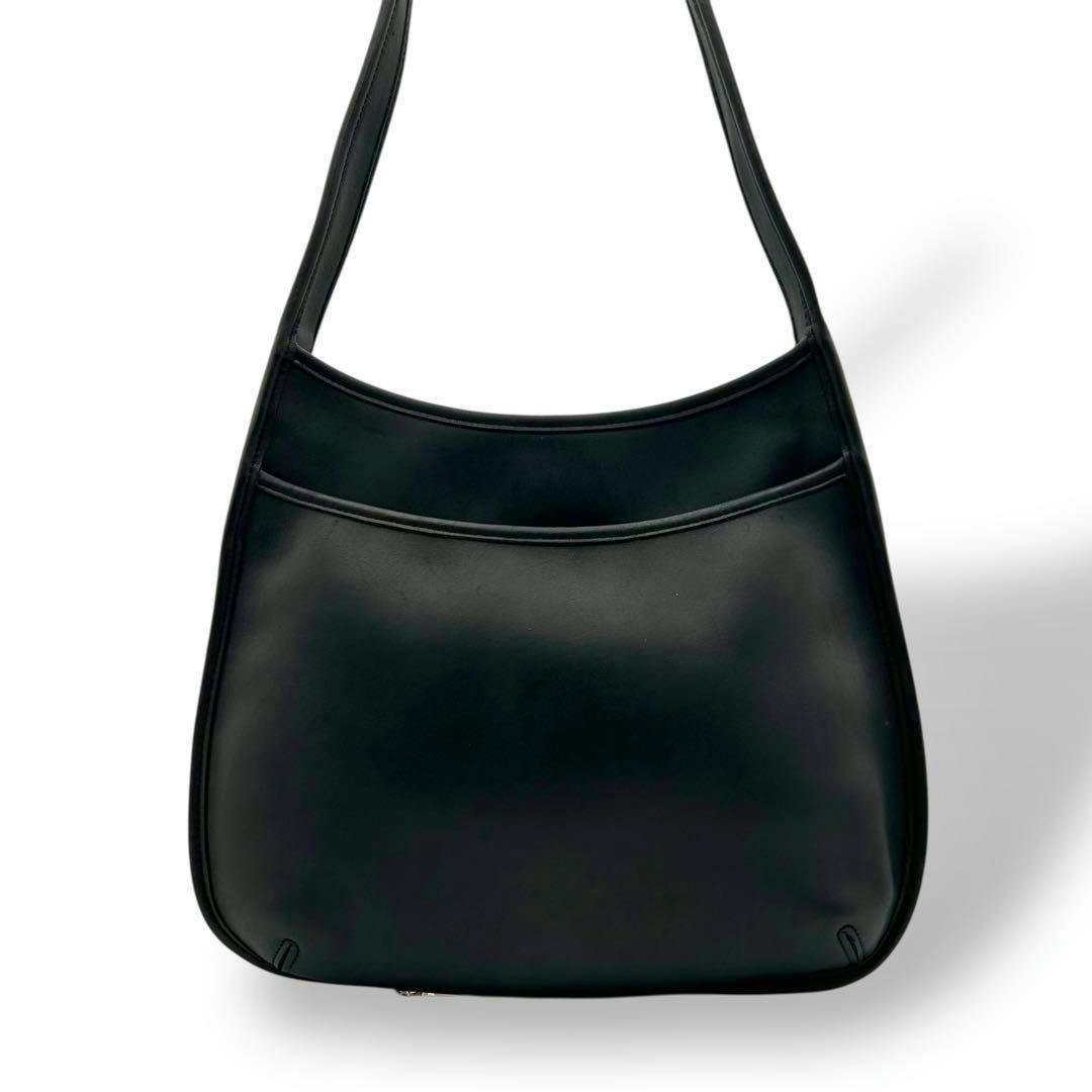Front view of a black Coach leather shoulder bag on a white background.
