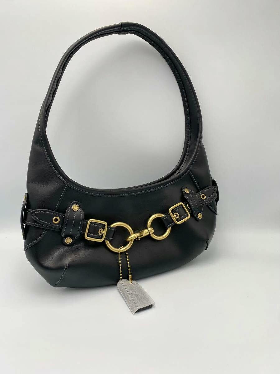 Black Coach leather shoulder bag with gold ring-and-buckle hardware shown on a white background.
