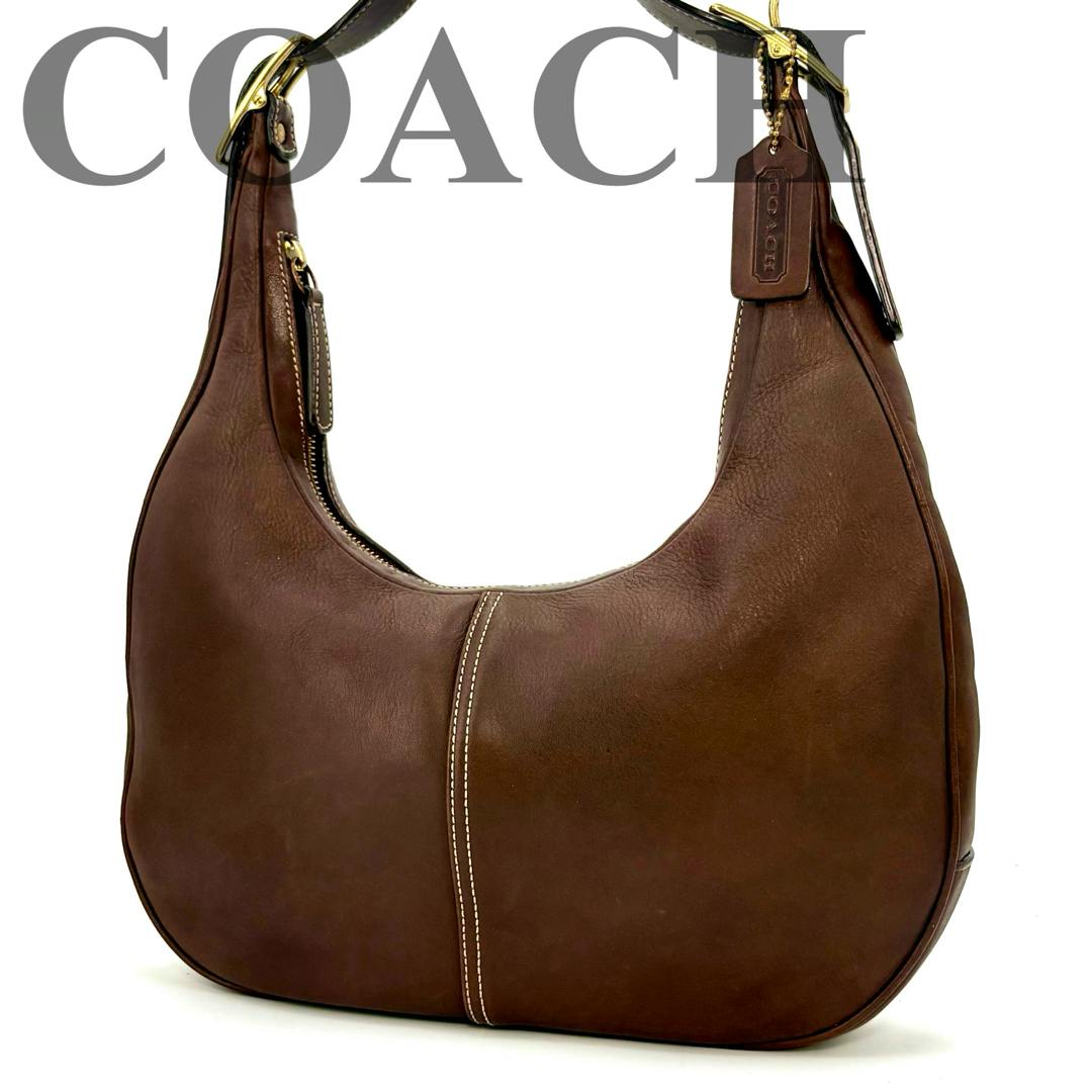 Brown COACH one-shoulder leather crescent (moon) bag photographed on a white background.