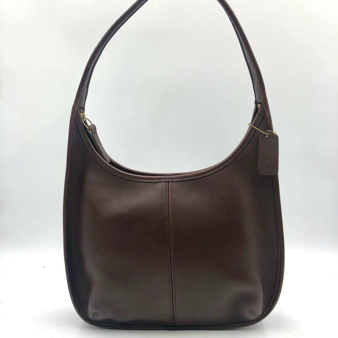 Front view of a brown Coach Ergo leather shoulder bag with strap and hang tag.