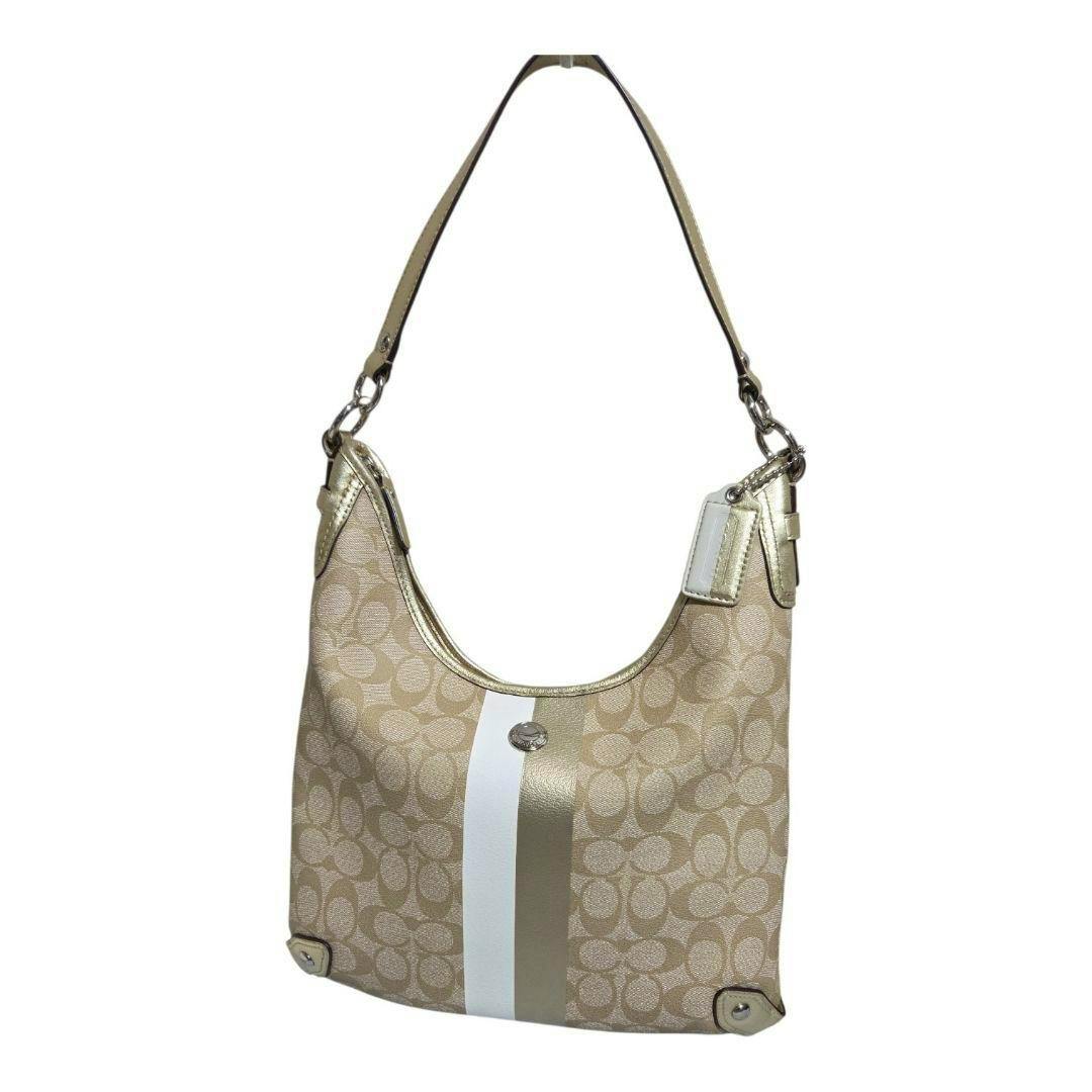 Front view of a beige Coach signature canvas 2WAY shoulder bag with a vertical white and gold stripe and gold-tone hardware.