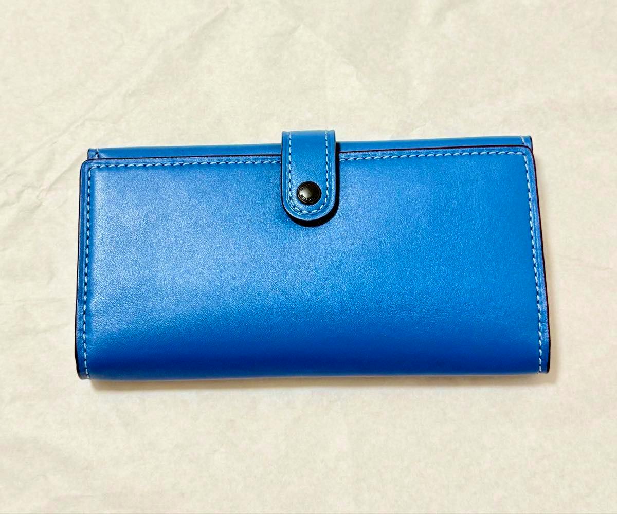 A blue long wallet laid flat showing the front exterior with a snap-closure strap.