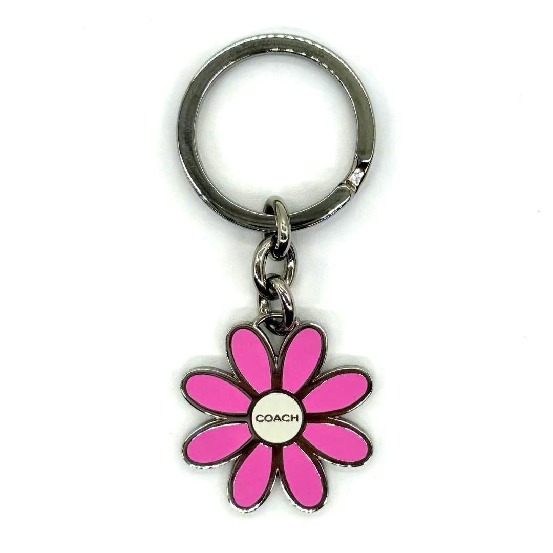 Pink flower-motif Coach key ring with a metal split ring and short chain on a white background.