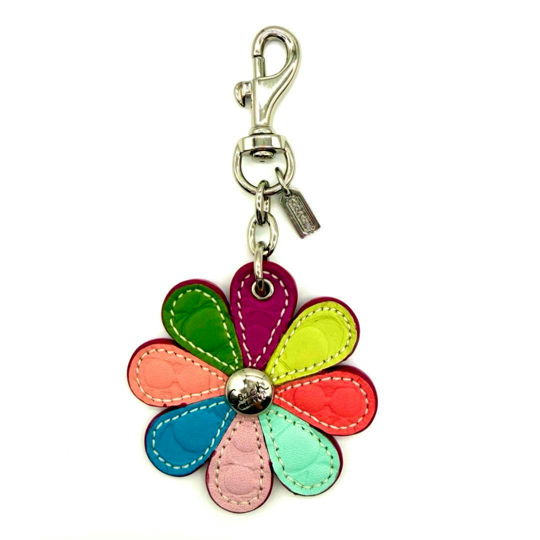 Multi-color leather flower-shaped Coach key ring with metal clasp and small Coach tag.